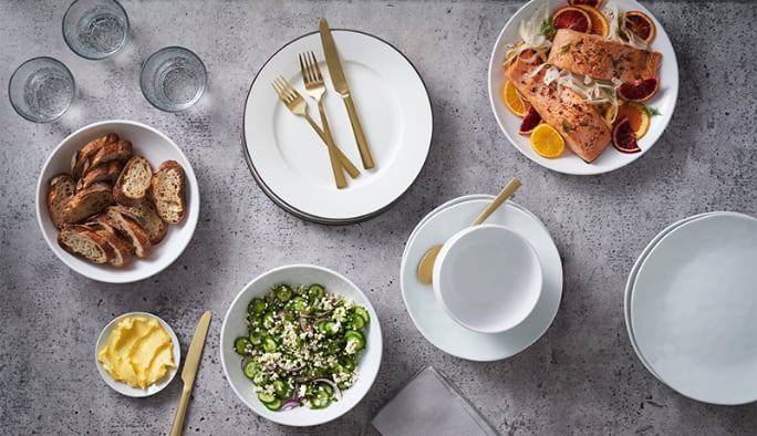 An array of plated food on PADERNO dinnerware with gold-finished stainless-steel flatware.