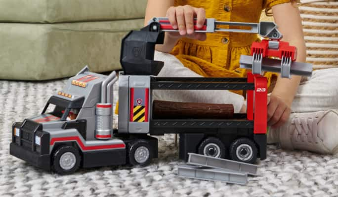 Child playing with Paw Patrol Big Truck Pups in living room.