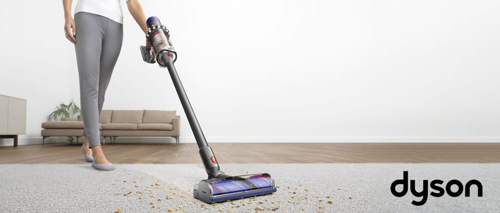 Person cleaning carpet with Dyson V10 Animal+ Cordless Vacuum