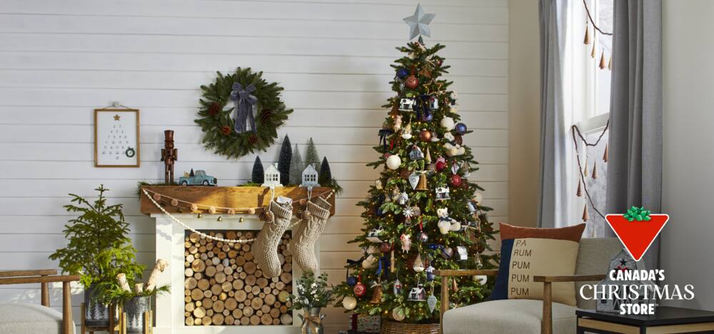 CANVAS Countryside Christmas decorations on a tree and fireplace mantel in a living room setting.