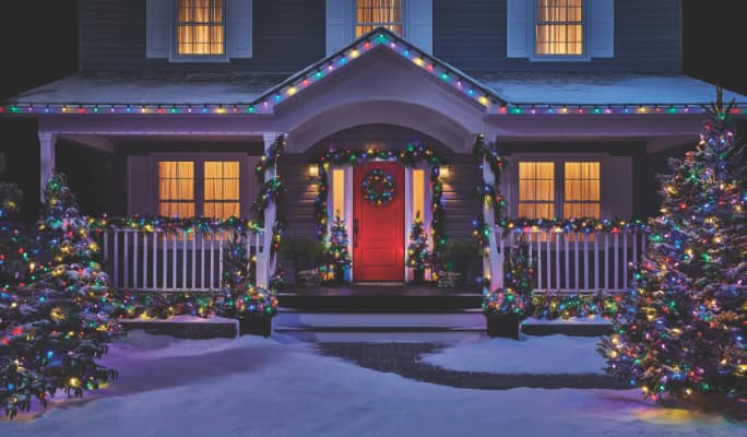 Extérieur d’une maison décoré de lumières de Noël NOMA colorées.