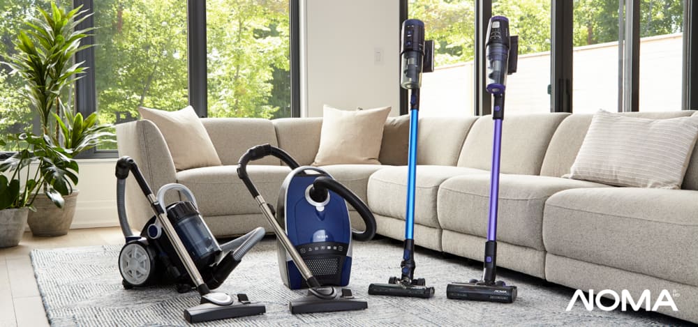 Two canister vacuums and two cordless stick vacuums in a bright, modern living room.