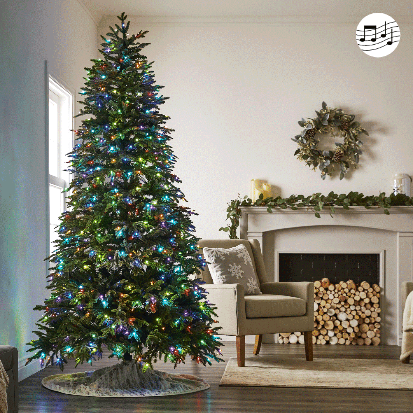NOMA 7.5-ft Advanced Aurora music & light show Christmas tree next to a fireplace sitting area.