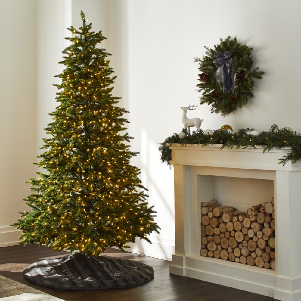 NOMA 7-ft Maine Tree next to a fireplace.