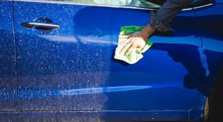 Une personne nettoyant une voiture  