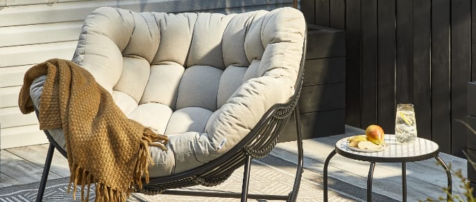 Outdoor lounge chair with throw blanket.