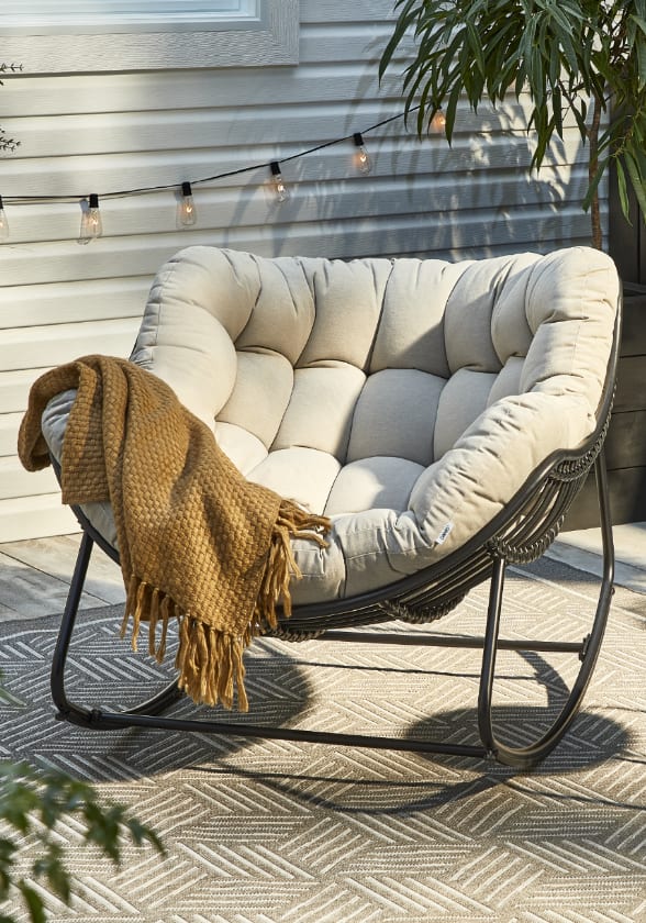 Outdoor lounge chair with throw blanket.