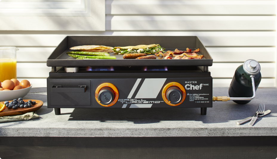 MASTER Chef® Grill Turismo 2-Burner Tabletop Griddle grilling hot dogs and veggies outside. 