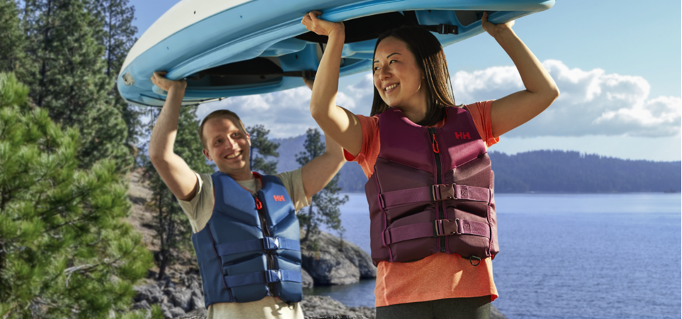 Two people carrying a kayak over their heads