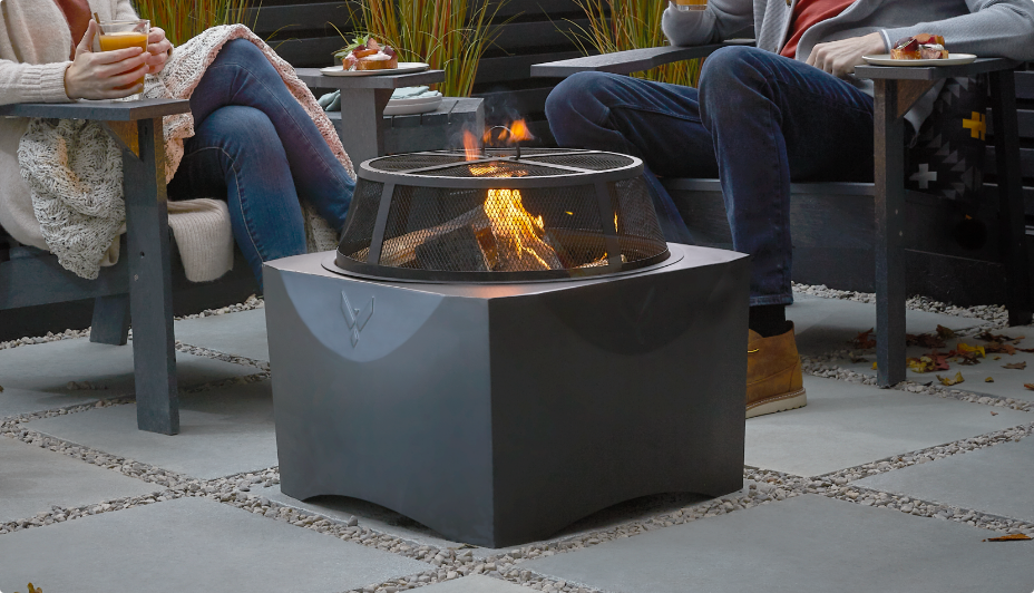 Two people sitting on Muskoka chairs enjoying the fire outdoors.