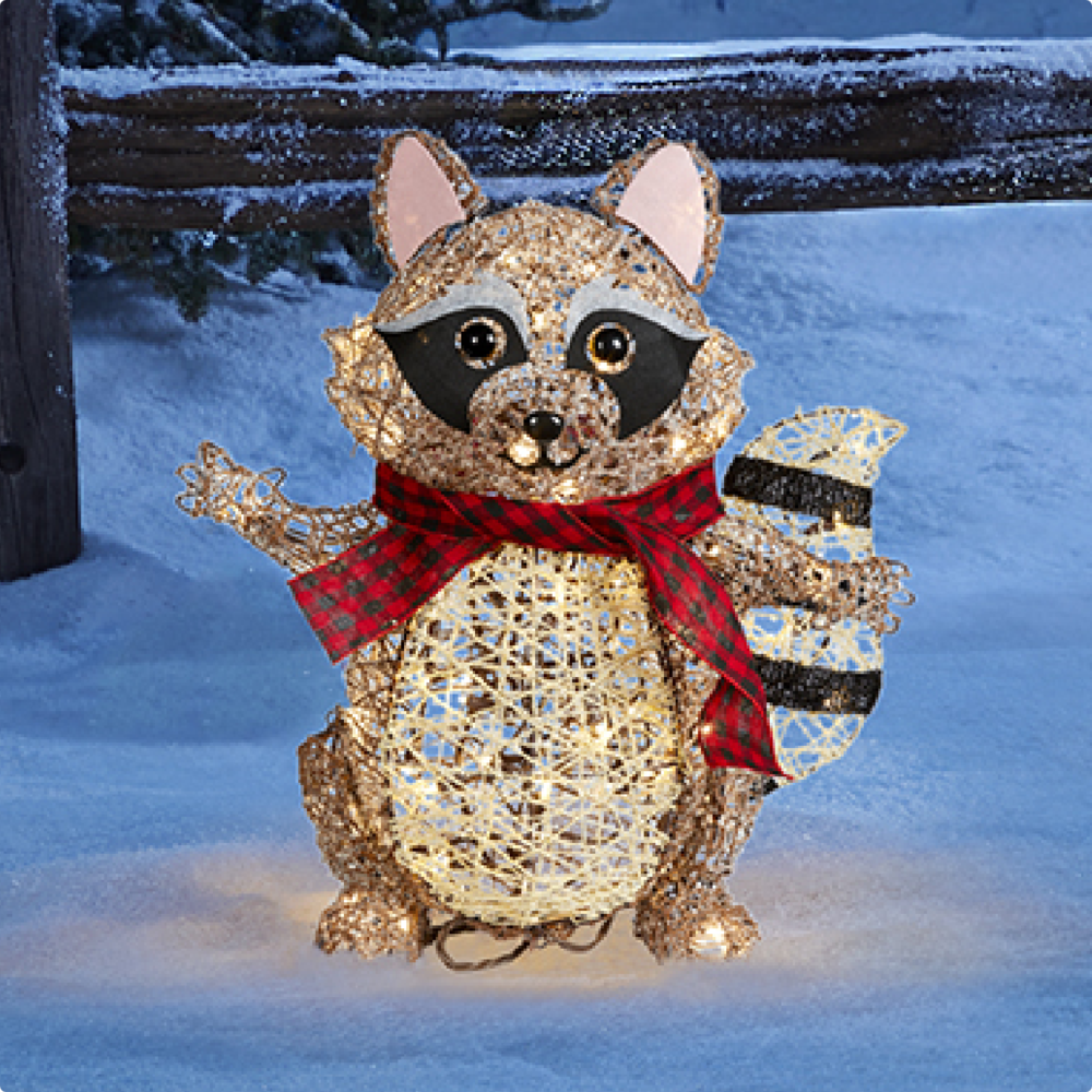 CANVAS Canadian Cabin raccoon figure lit up on a snowy lawn