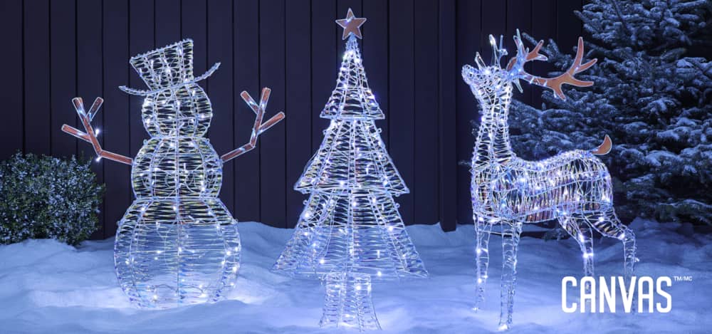 Bonhomme de neige, arbre et renne en fil métallique iridescents et illuminés sur un parterre enneigé.