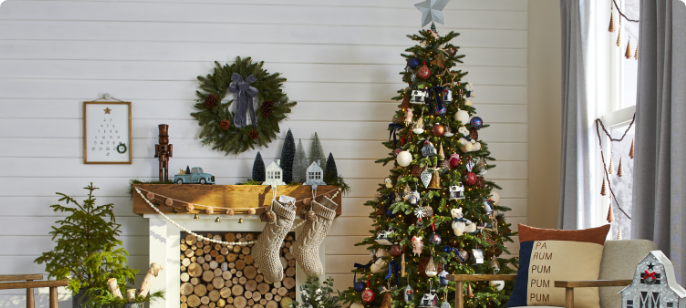 A living room and Christmas tree decorated with CANVAS ornaments, wreaths and accessories.