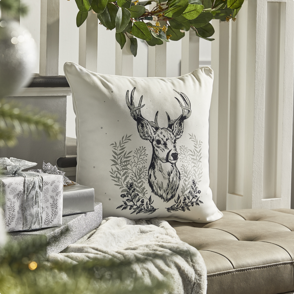 Silver Stag Head Cushion on an ottoman.