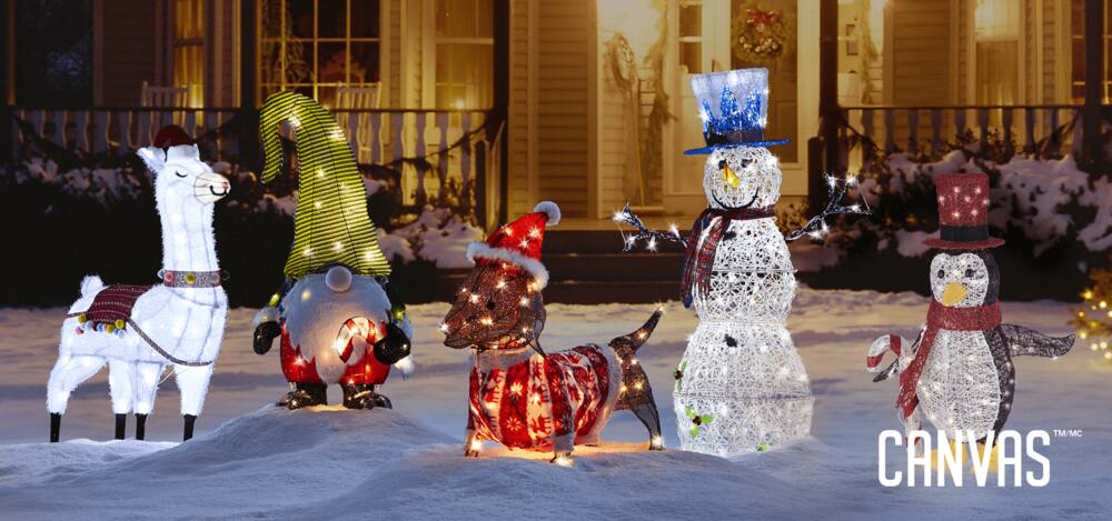 An assortment of lit-up Whimsical Christmas decorations on a front lawn of a house including a snowman, llama, gnome, penguin, and daschund.