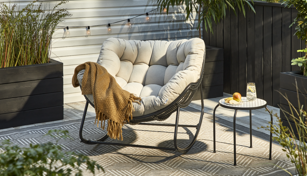 Fauteuil berçant papasan Cove avec couverture décorative. 