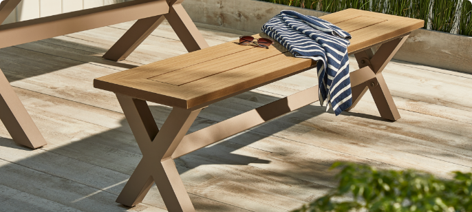  CANVAS Belwood Dining Bench on wooden backyard porch dining area featuring wood accents, sunglasses and stripped scarf on the bench.