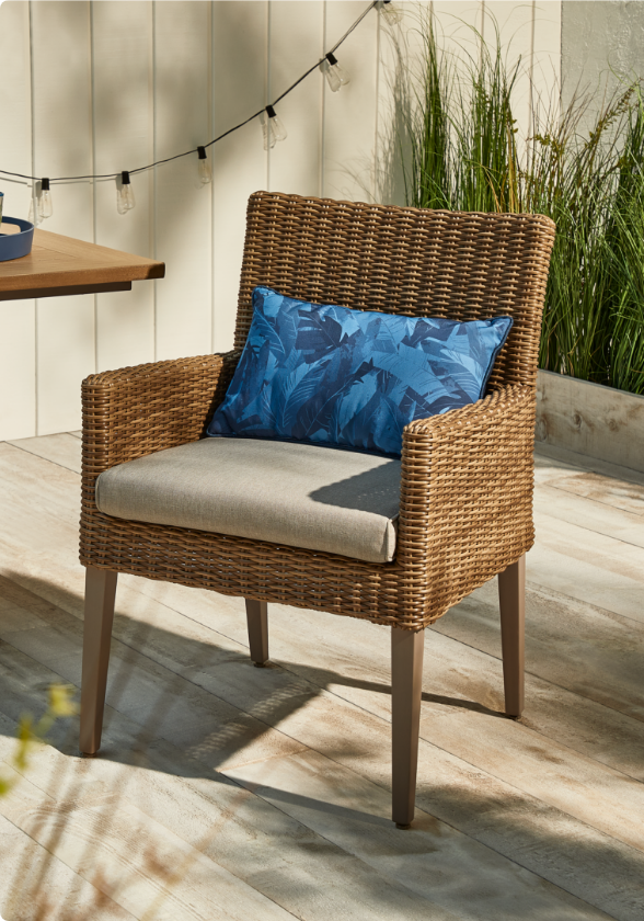 CANVAS Belwood Dining Chair on wooden backyard porch with a cushion seat and throw pillow.