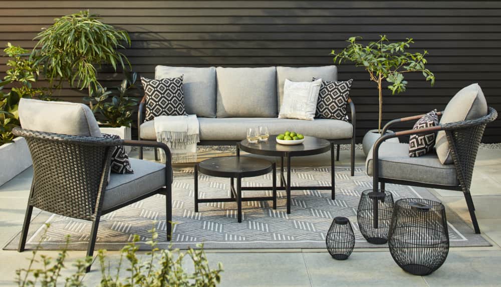 CANVAS Jasper 5-piece conversation set displayed on a modern patio featuring decorative pillows, plants, outdoor rug and lanterns. 