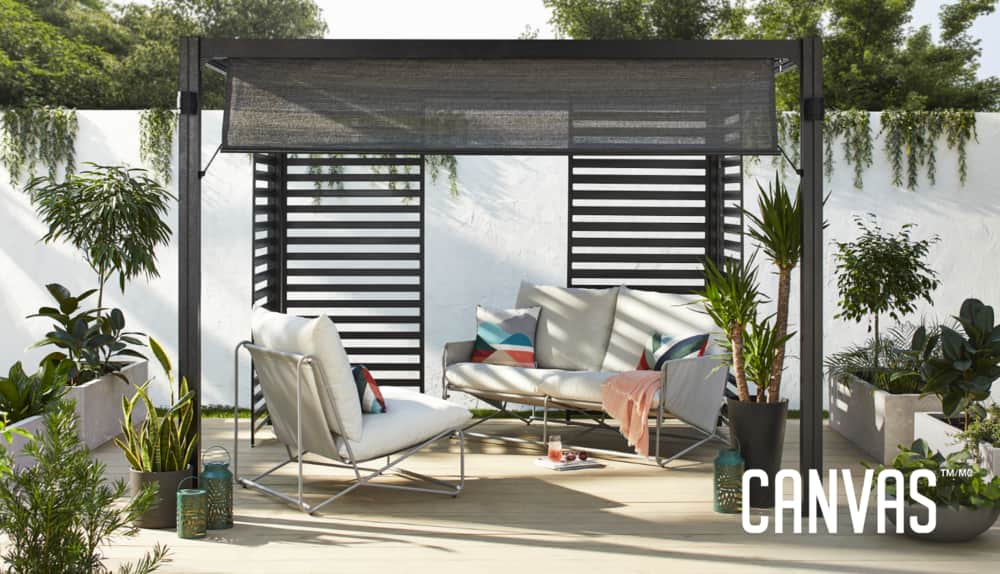 Pergola CANVAS Horizon dans la configuration de détente confortable installée sur une terrasse d’arrière-cour. 