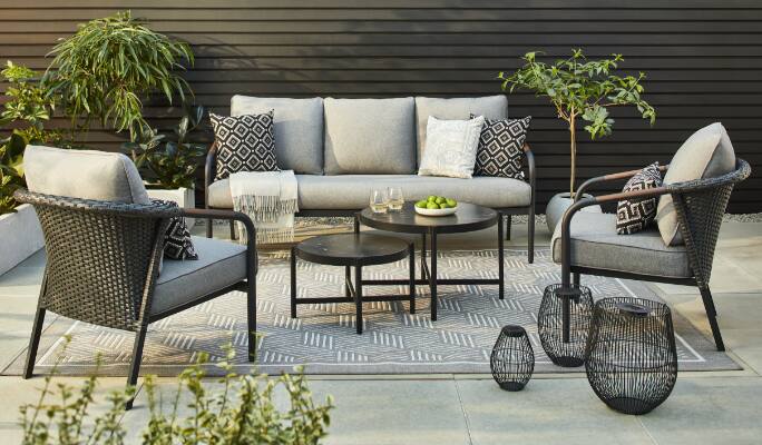 Sofa, fauteuils et tables de 2 pièces de la collection de détente CANVAS Jasper installés sur une terrasse.