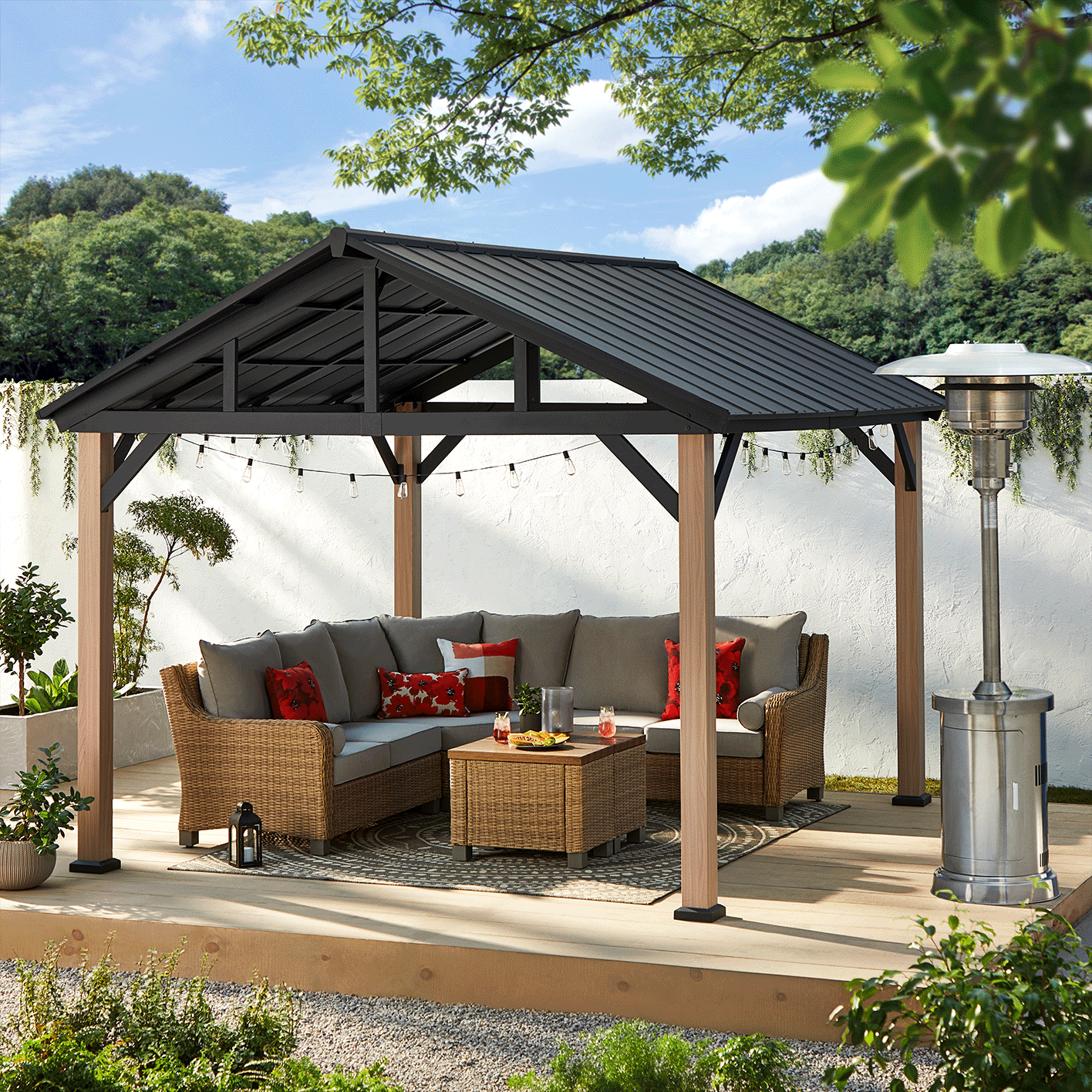 CANVAS Homestead Gazebo set up on wooden backyard porch with outdoor heater and sectional set. 