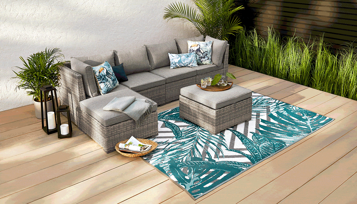 CANVAS Bala 6-piece Sectional Set set up on a patio with ottoman and tropical printed rug.