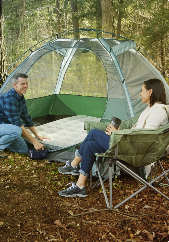 Un matelas pneumatique est gonflé avec une pompe à air rechargeable à double puissance Woods BLAST UBS dans une tente Woods ILLUMINATE.