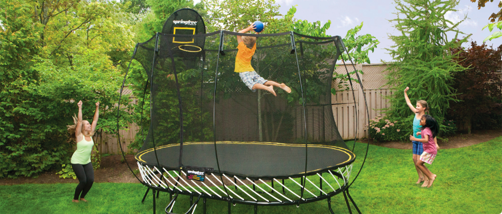 Child playing with a ball on a trampoline.
