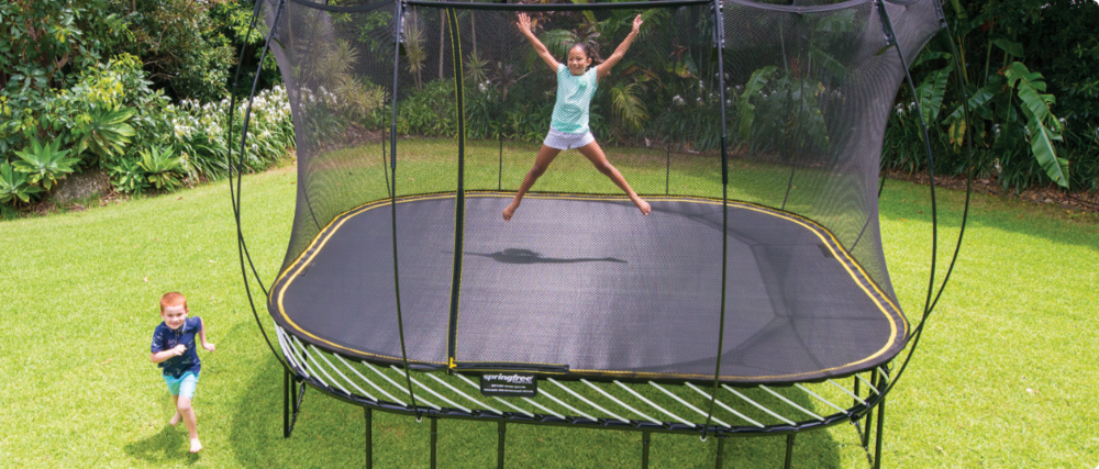 Un enfant joue avec un ballon sur un trampoline.