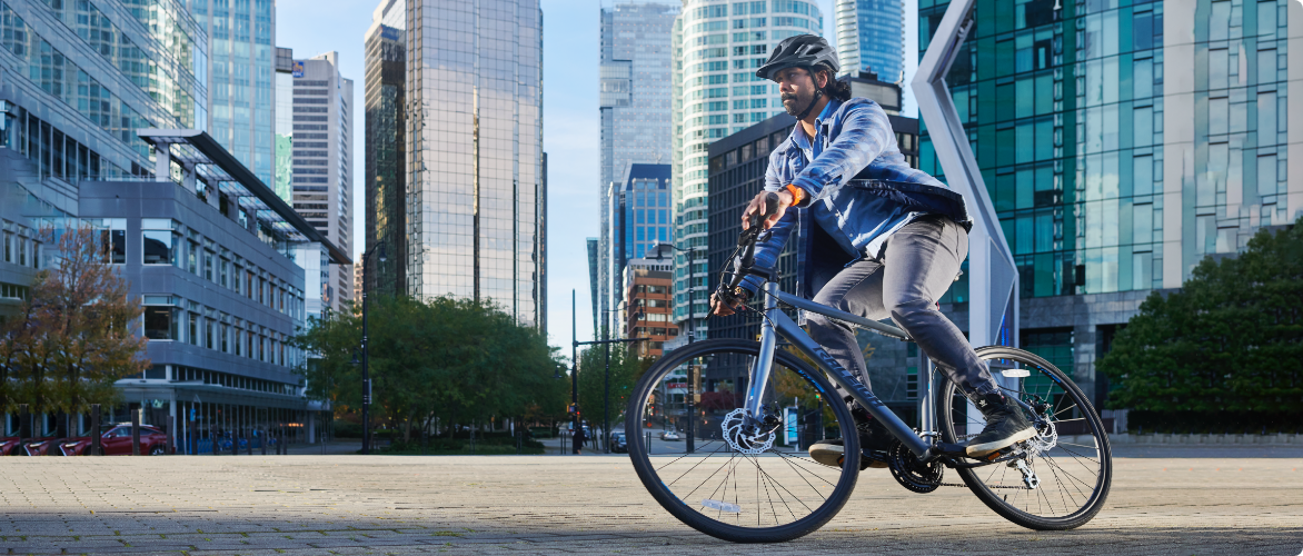 A person rides a Raleigh bicycle along an urban city street.