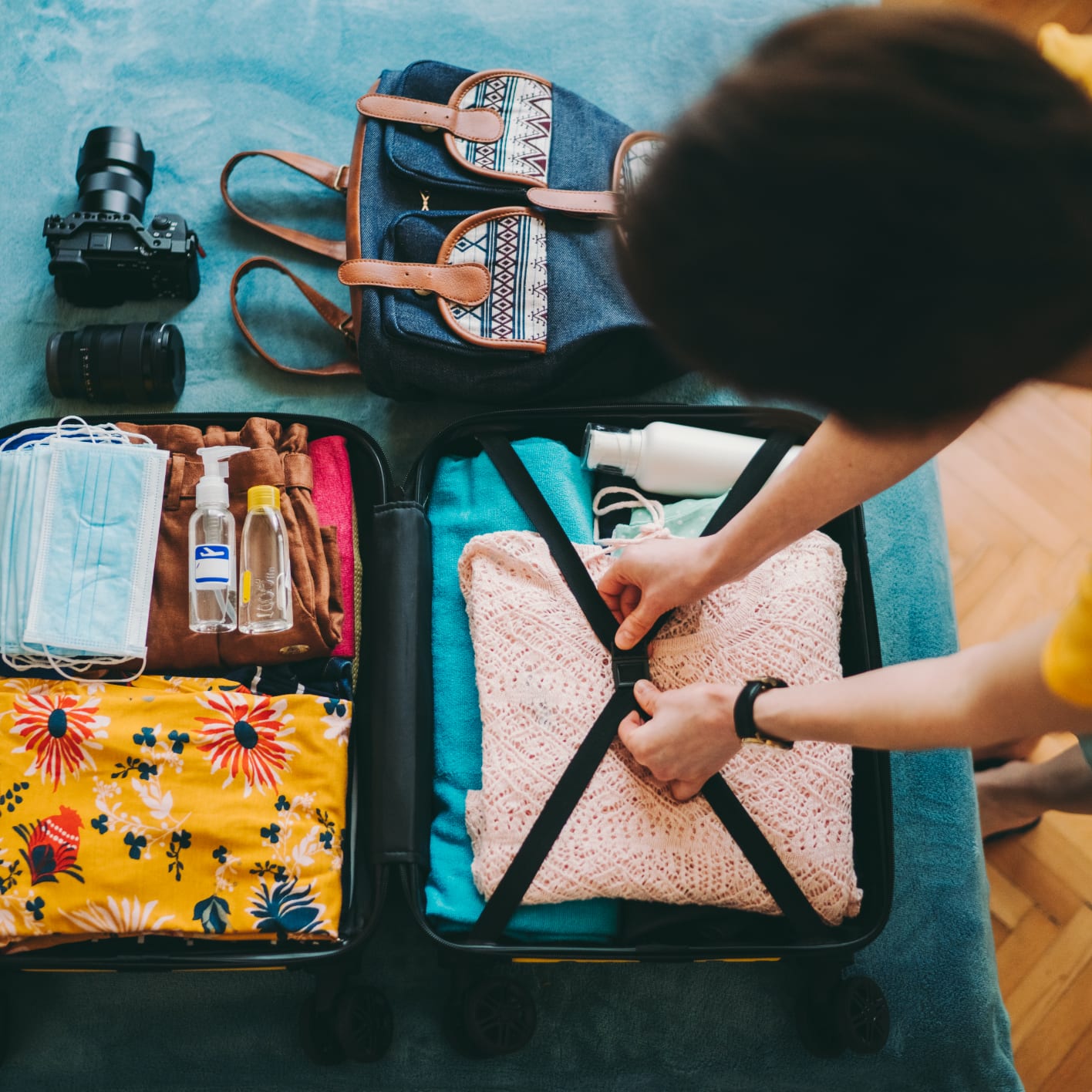 A traveller finishes packing his well-organized suitcase. 