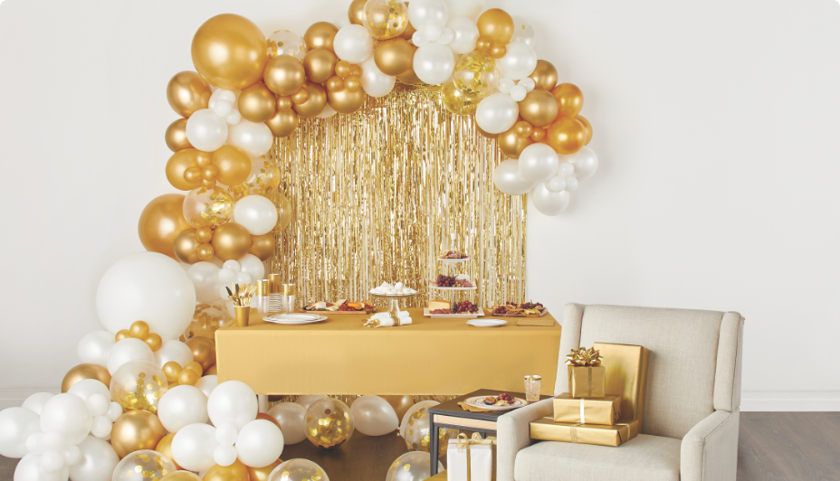 A table decoracted with gold and white balloons