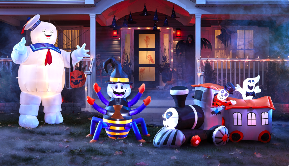 Gemmy Airblown Stay Puft, For Living Happy Spider inflatable, and spooky train in front of a house decorated for Halloween.