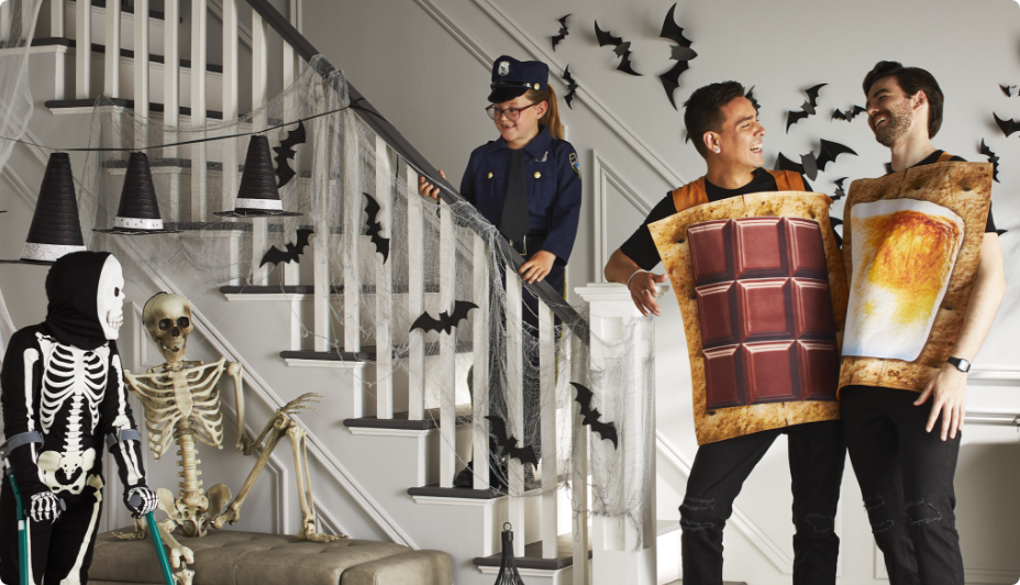 Man wearing an alien costumes with a woman dressed as a witch and two boys wearing Luigi and Mario costumes at home.