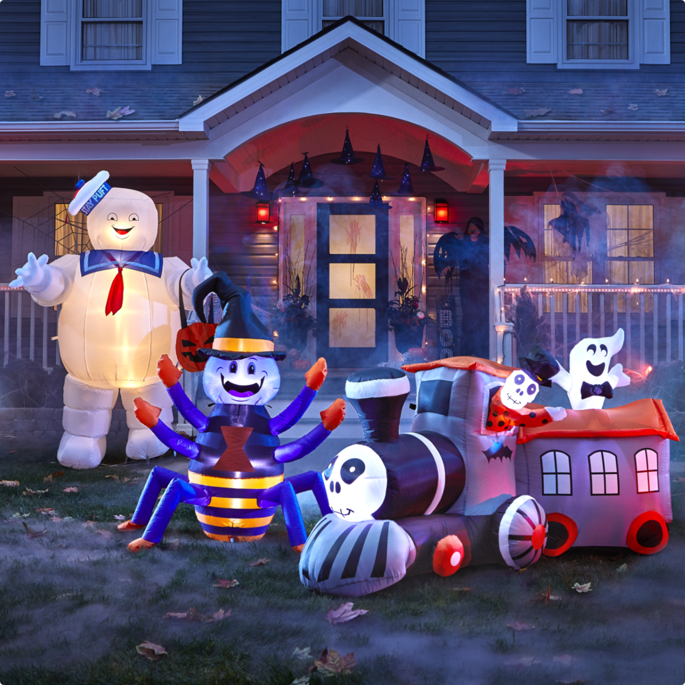 Gemmy Airblown Stay Puft, For Living Happy Spider inflatable, and spooky train in front of a house decorated for Halloween.