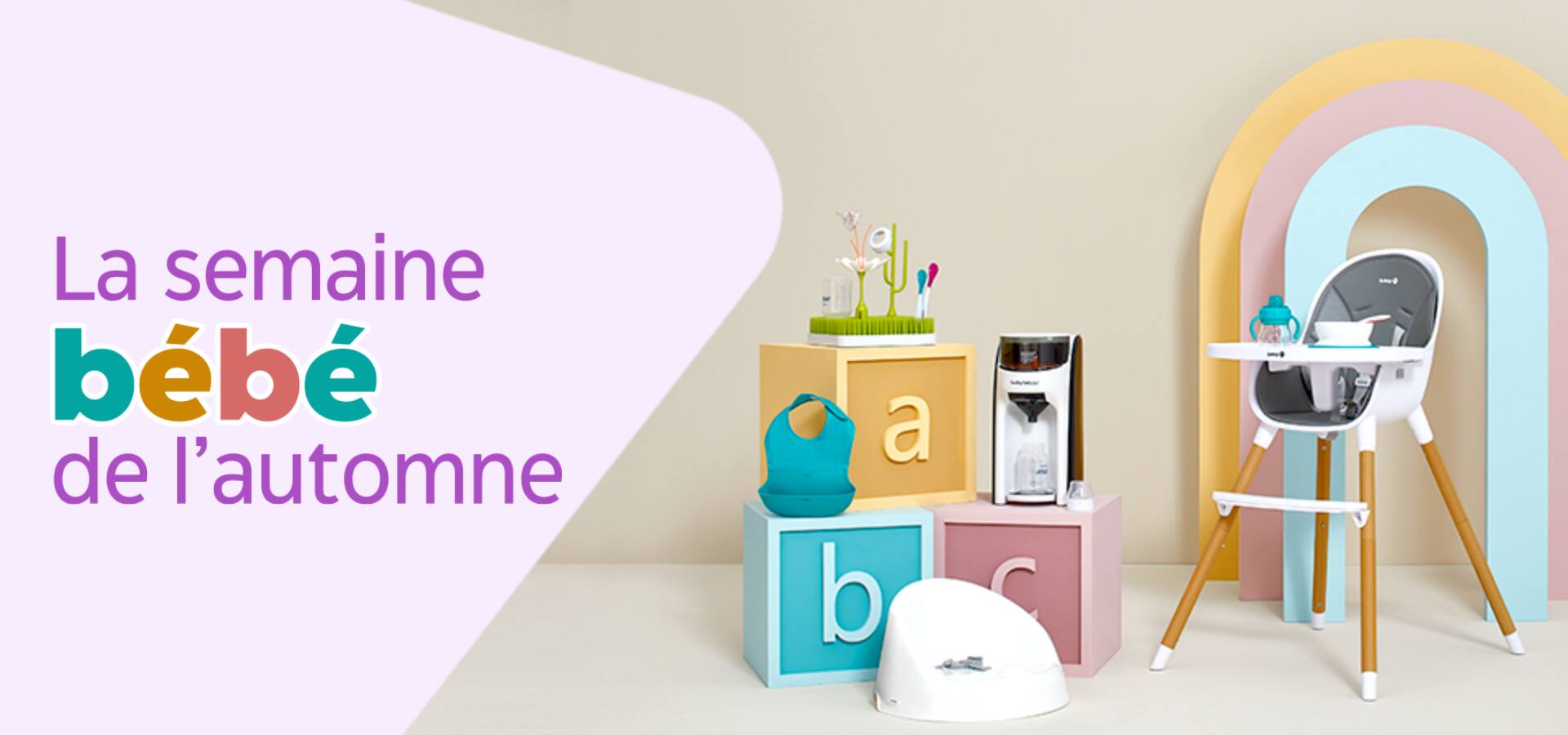 Une chaise haute, un petit pot, un centre d'activités et d'autres articles pour bébés sont présentés sur et autour de trois blocs de lettres géants.