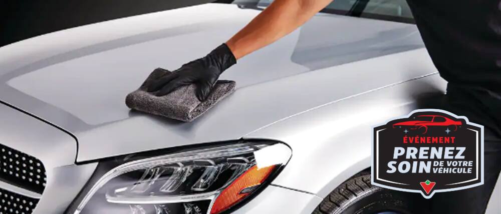 Une main munie d’un gant en nitrile essuie le capot d'une voiture avec une serviette en microfibres SIMONIZ.