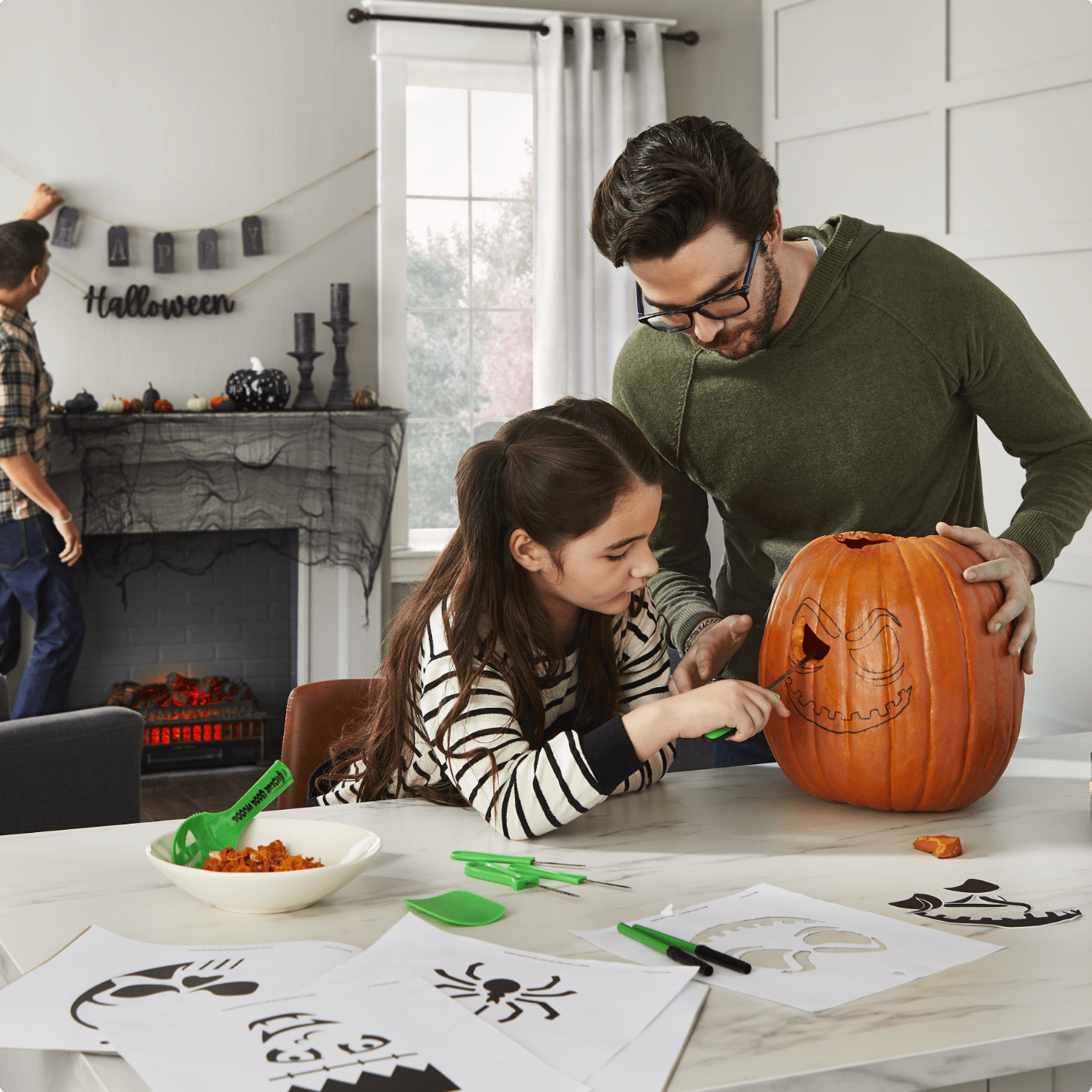 Dad and daughter carving pumpkin. 