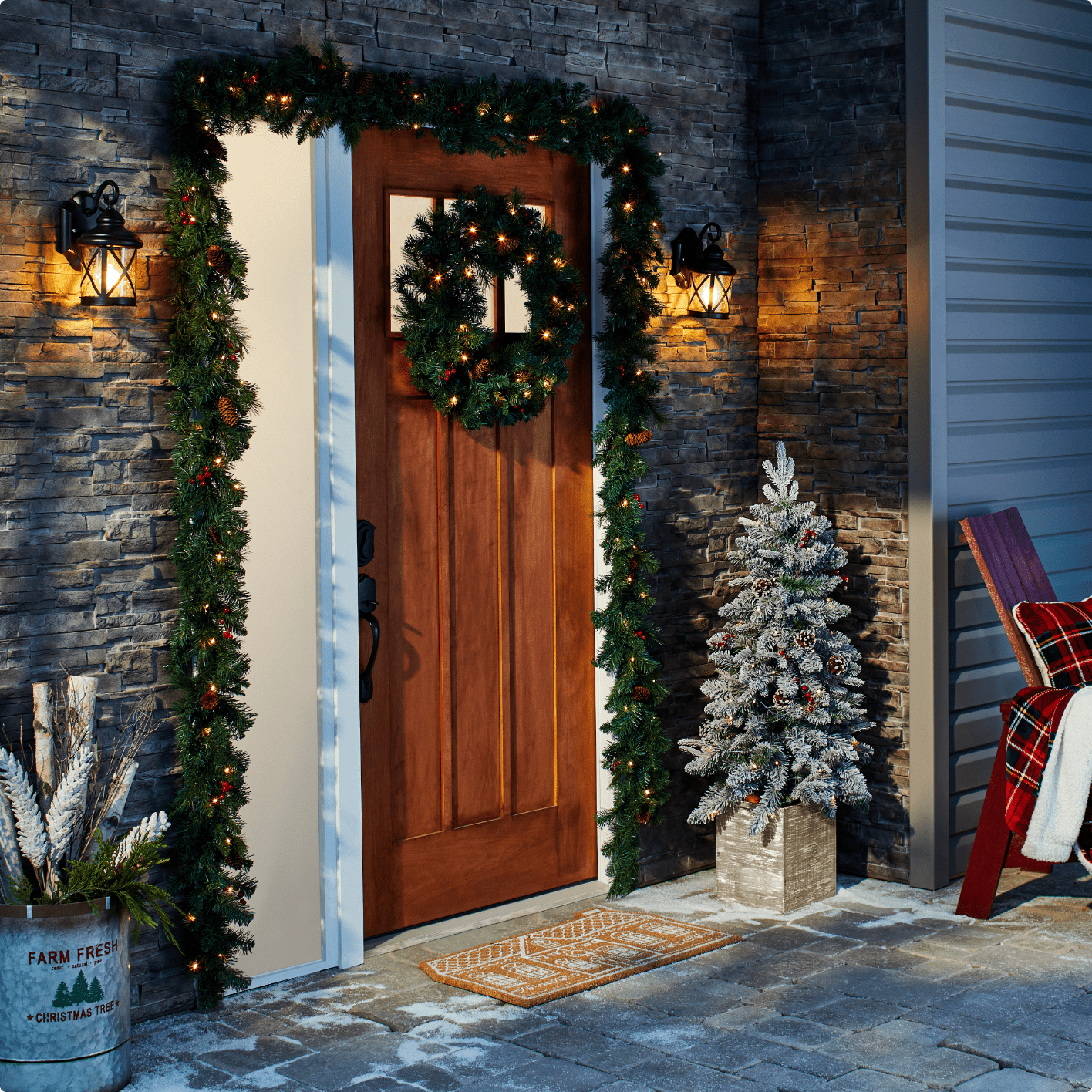 Couronne de Noël et paillasson en fibres de coco sur un porche d’entrée.