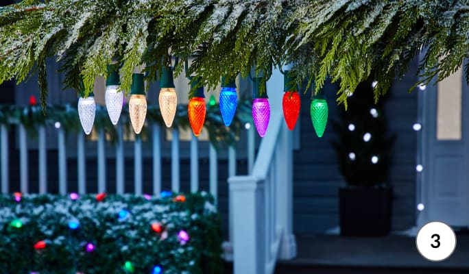 NOMA Advanced Custom LED light bulbs in different colours hanging from tree branch