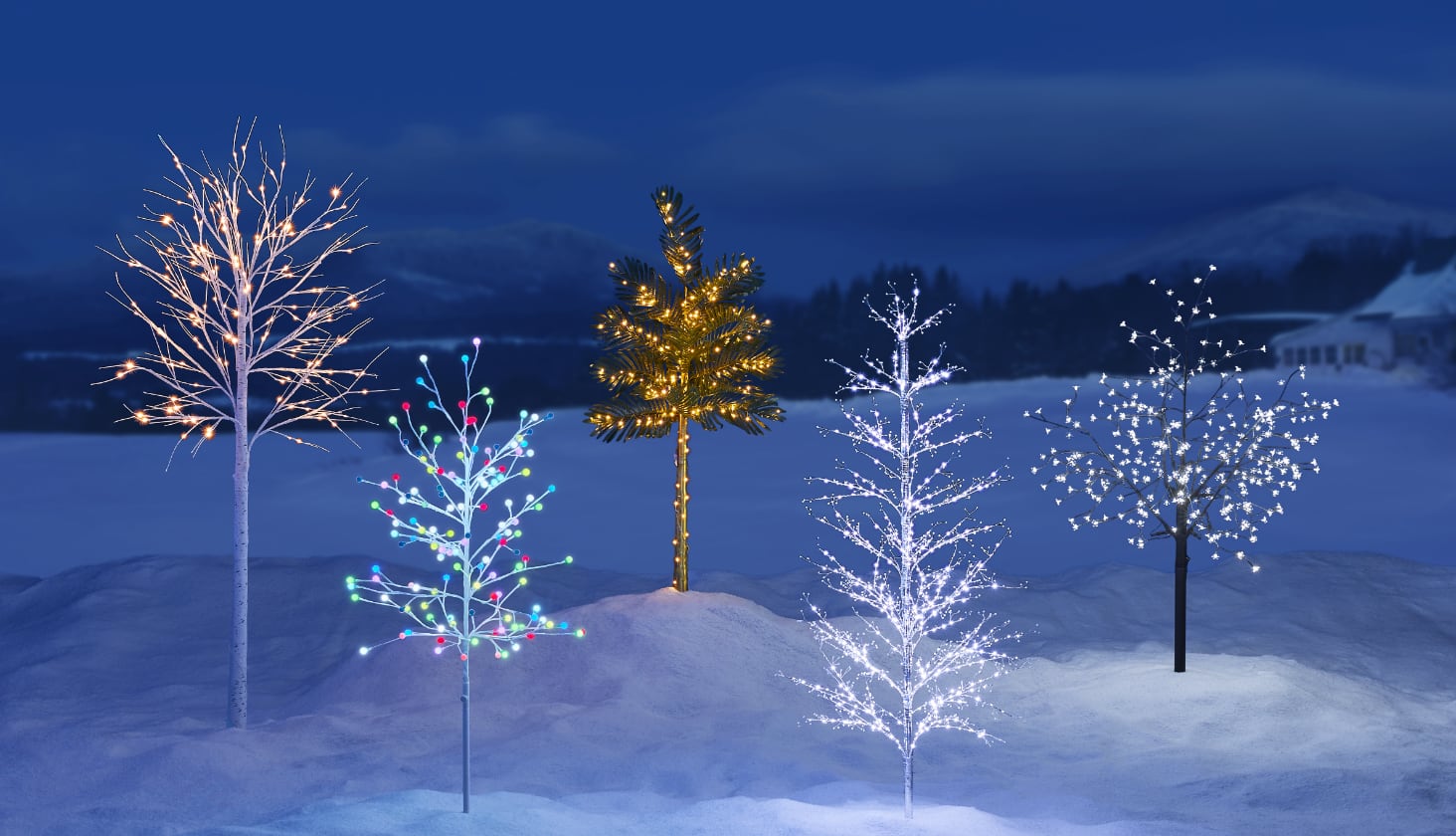 A range of CANVAS Outdoor Pre-Lit Trees on a snowy lawn including the Birch Tree, Bossom Tree and LED Palm Tree.