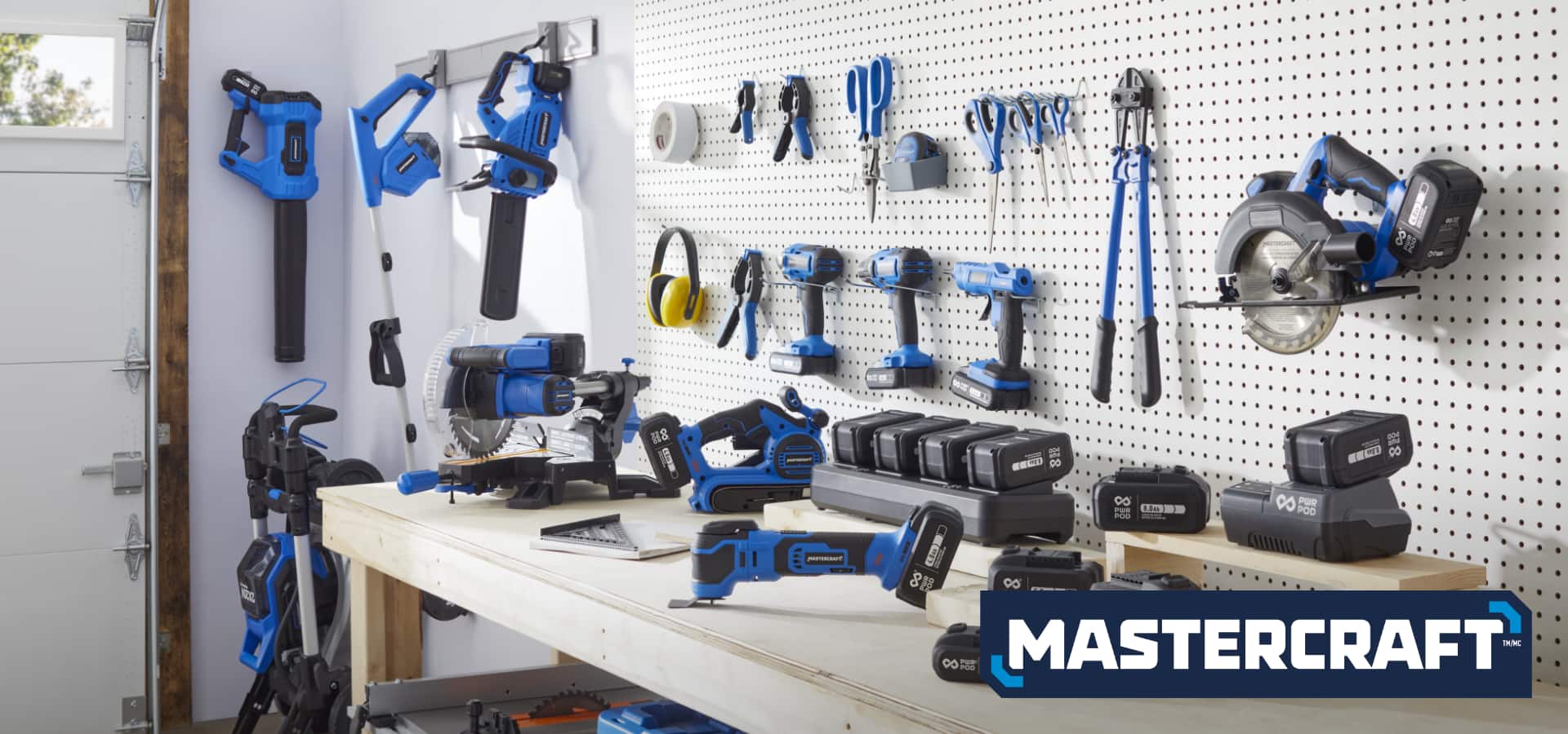 Assortment of Mastercraft tools and PWR POD batteries on garage workbench 