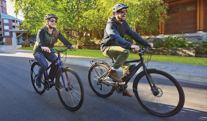 Two people riding bikes side by side  