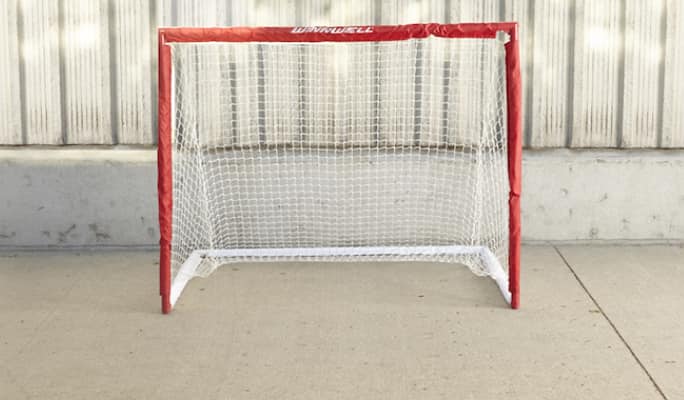 Hockey net in front of concrete wall  