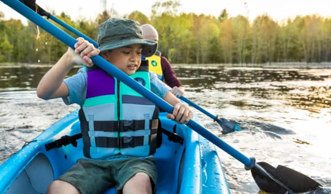 Un enfant pagayant dans un kayak  