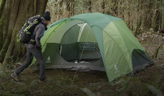 Person beside a Woods tent  