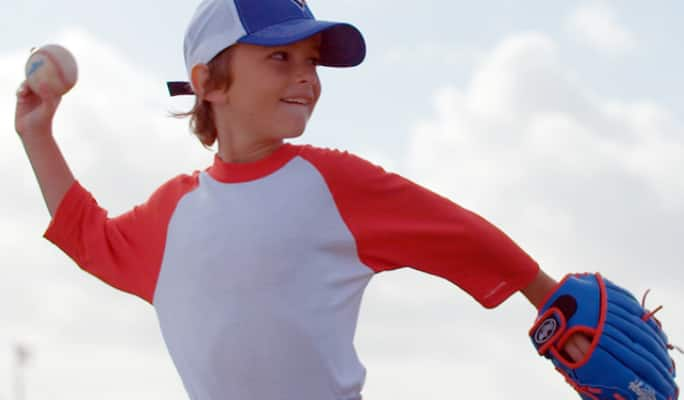 Un enfant lançant une balle de baseball 