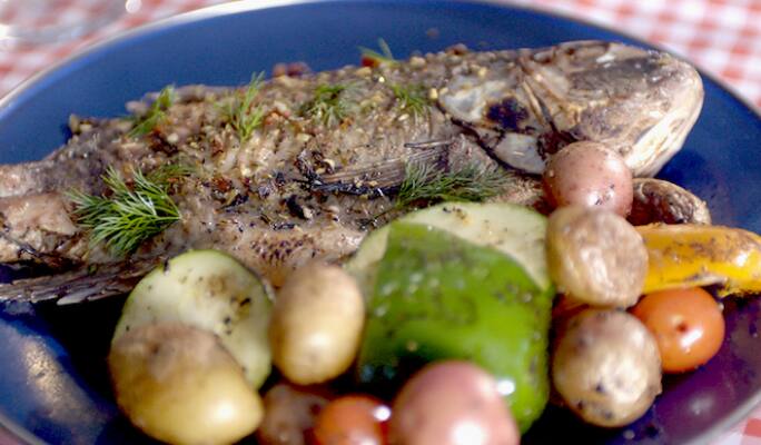 Du poisson et des légumes grillés sur une assiette  