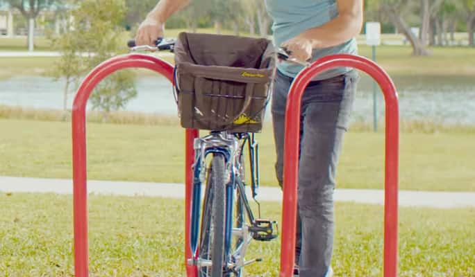 Une personne enchaîne son vélo dans un parc  